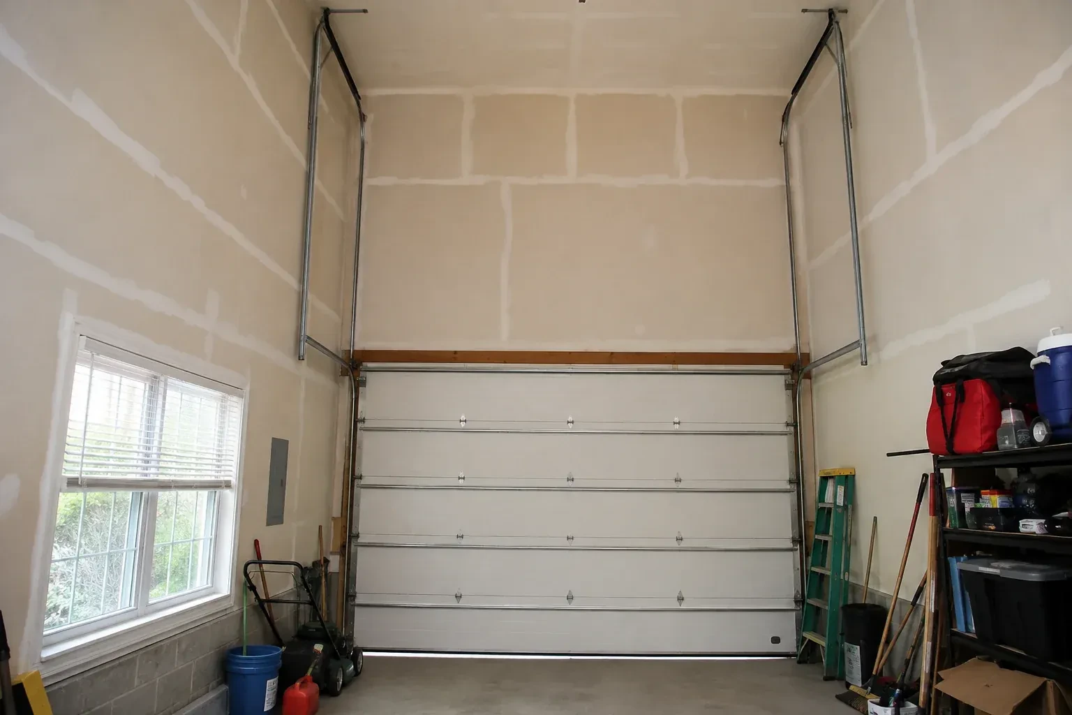 Tall garage interior with a sectional door and tracks extending into overhead space. — High-Lift Garage Door Conversion, Toronto